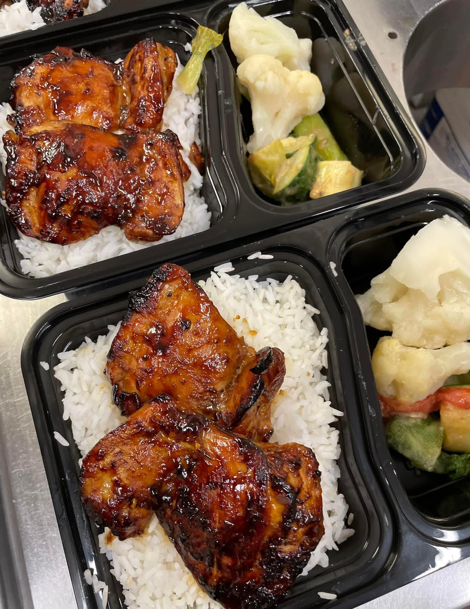 Actual chicken portions served with rice and vegetables in meal trays