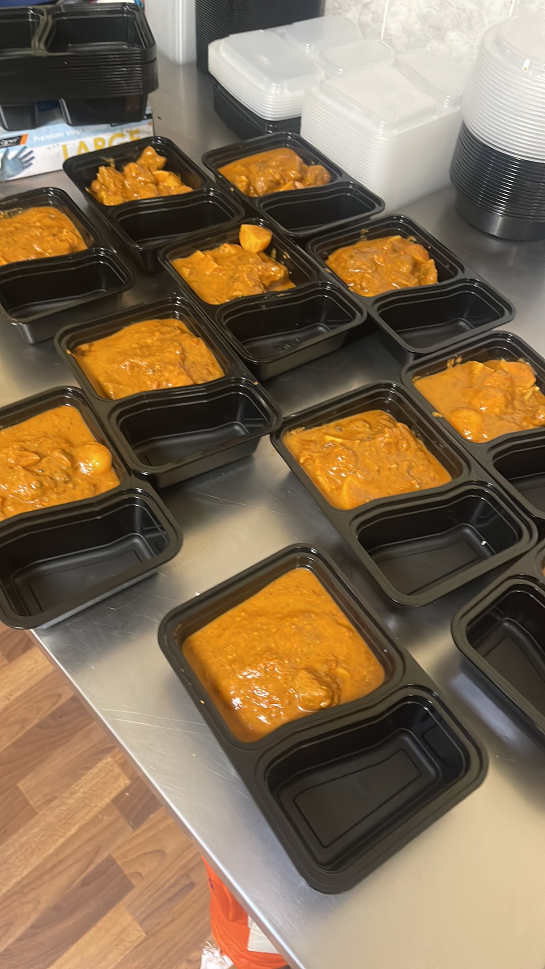 Individual meal portions being prepared in black trays